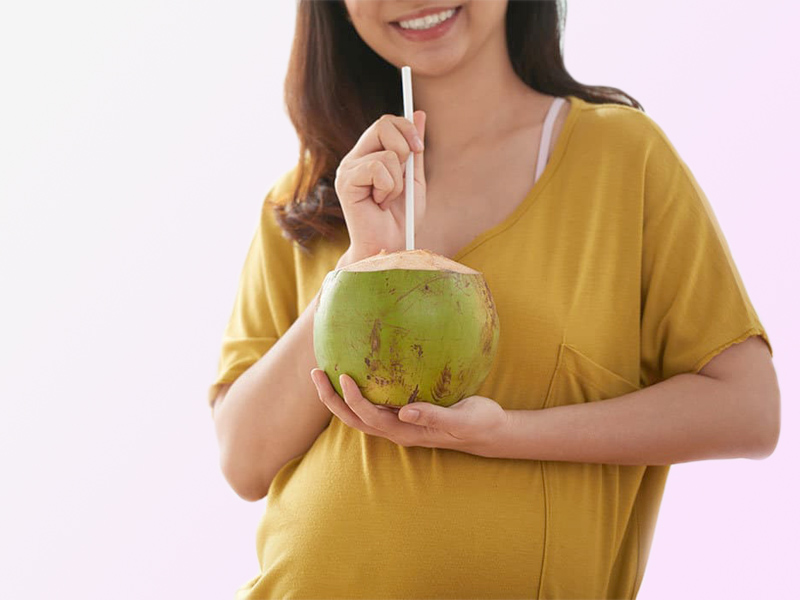 uống nước dừa có thể giúp bà bầu hạ nhiệt trong lúc mang thai